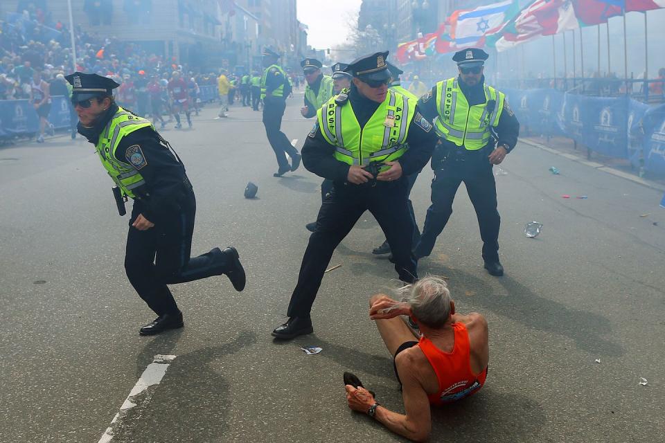 <p>Police officers with their guns drawn hear a second explosion near the finish line of the 117th Boston Marathon. The first explosion knocked down 78-year-old marathoner Bill Iffrig. </p>