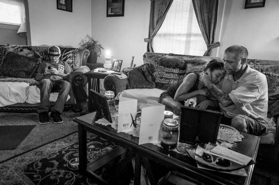 <p>Gene Robinson, right, caresses his wife Terri Fugate while Terri’s son Larry Fugate, far left, looks at his phone in their Middletown, Ohio home. Both men are recovering heroin addicts.<br> (Photograph by Mary F. Calvert for Yahoo News) </p>