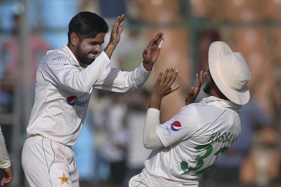Pakistan Babar Azam, left, celebrates with teammate after the dismissal of Australia's Alex Carey on the second day of the second test match between Pakistan and Australia at the National Stadium, in Karachi, Pakistan, Sunday, March 13, 2022. (AP Photo/Fareed Khan)