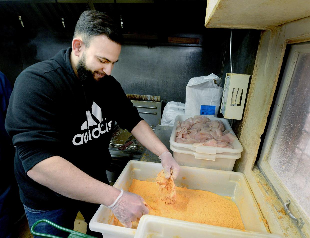 Co-owner of Carter's Fish Market Jay Qattum breads Copi before frying it up at the market Friday, March 24, 2023.