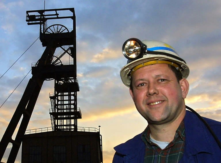 Un mineur pose devant un des chevalements de la mine de La Houve, dernière mine de charbon encore en activité en France, à Creutzwald, en Moselle, le jour de la fermeture du site, le 23 avril 2004 (JEAN-CHRISTOPHE VERHAEGEN)