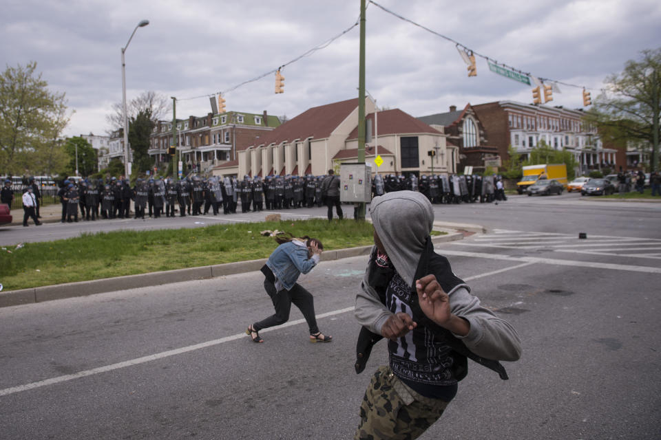 BALTIMORE, MD - APRIL 27: A man throws an object at officers during a protest for Freddie Gray near Mondawmin Mall in Baltimore, MD on Monday April 27, 2015. Gray died from spinal injuries about a week after he was arrested and transported in a police van. (Photo by Jabin Botsford/The Washington Post via Getty Images)