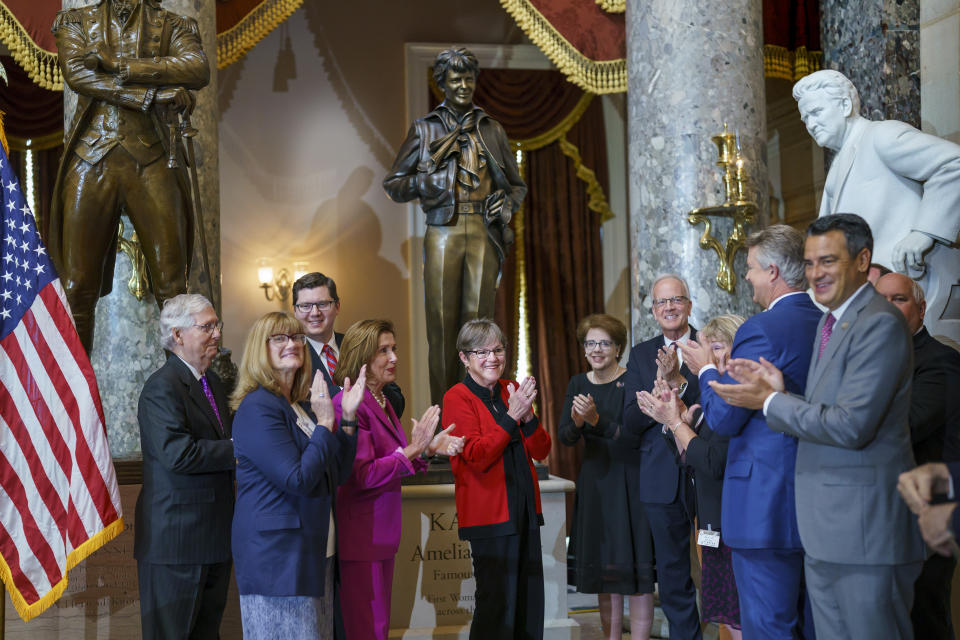 Kansas Gov. Laura Kelly, center, is joined by Speaker Nancy Pelosi, D-Calif., center left, Senate Minority Leader Mitch McConnell, R-Ky., far left, former Kansas Sen. Jerry Moran, center right, for the dedication and unveiling ceremony of a statue in honor of Amelia Earhart, one of the world's most celebrated aviators and the first woman to fly solo across the Atlantic Ocean, in Statuary Hall, at the Capitol in Washington, Wednesday, July 27, 2022. The statue of Amelia Earhart will represent the State of Kansas in the National Statuary Hall Collection. (AP Photo/J. Scott Applewhite)