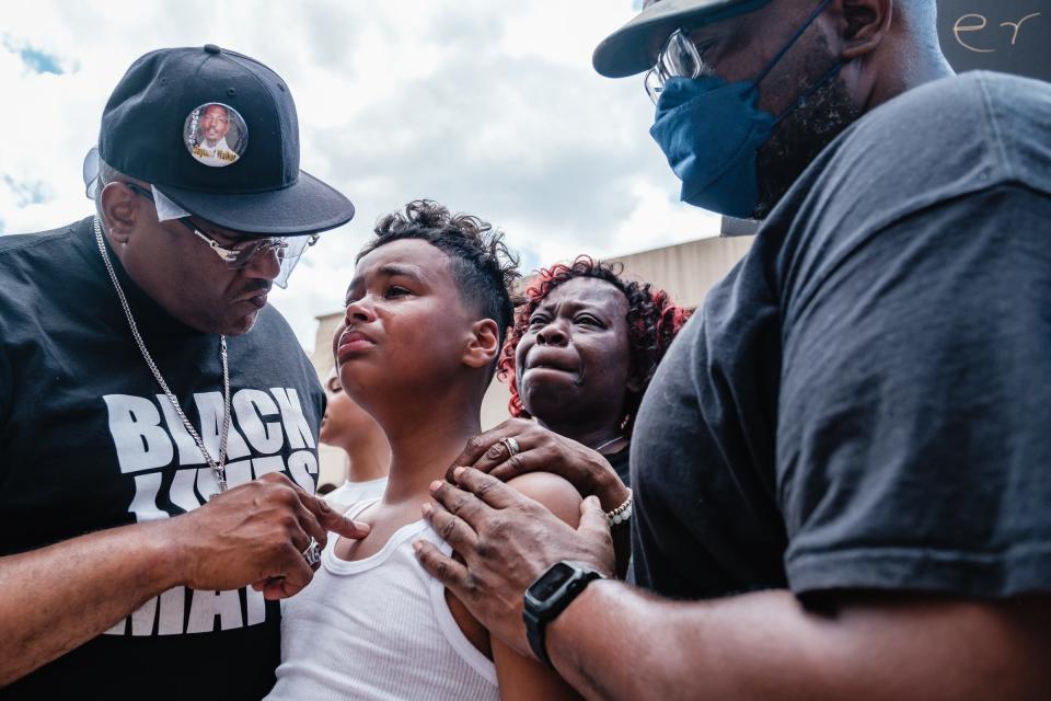 Javon Williams, 13, is comforted by the Rev. Jaland Finney, left, as he speaks at a rally after watching a police bodycam video of Jayland Walker. Lynnette Williams, center, reacts after Javon's impassioned speech.