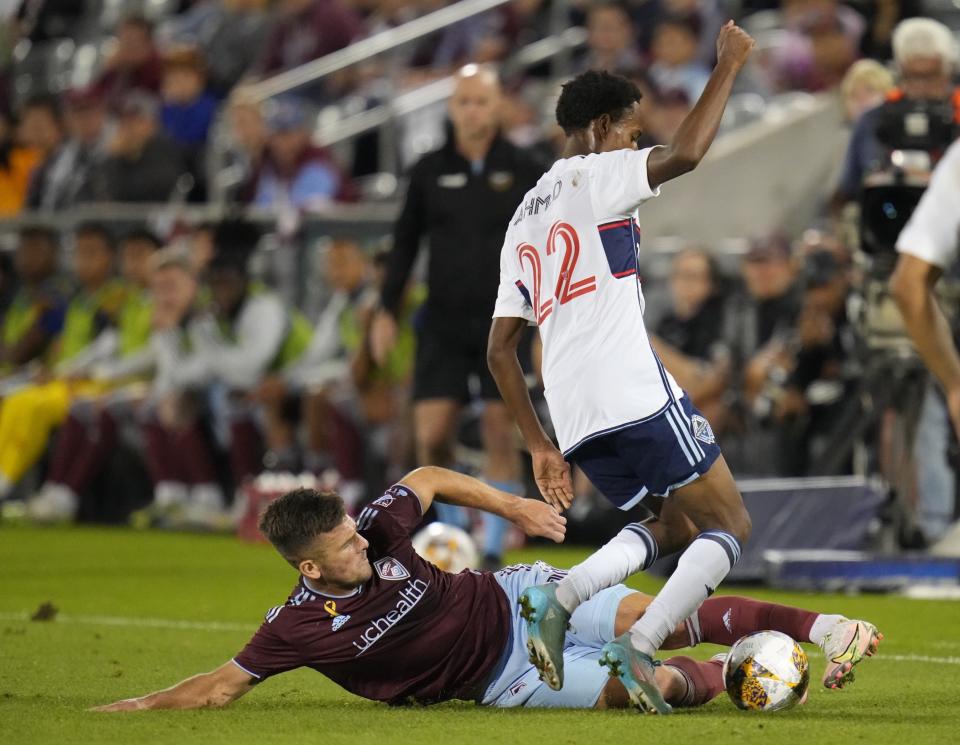 Colorado Rapids forward Diego Rubio (11) slide-tackles Vancouver Whitecaps forward Ali Ahmed (22) during the first half of an MLS soccer match Wednesday, Sept. 27, 2023, in Commerce City, Colo. (AP Photo/Jack Dempsey)