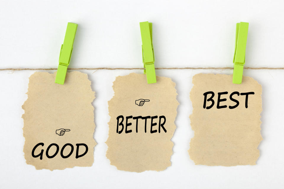 GOOD BETTER BEST writen on old torn paper with clip hanging on white background