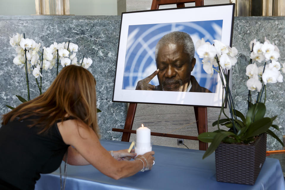 An UN staff member puts a candle in front of portrait of former United Nations Secretary General Kofi Annan prior to a ceremony of UN staff to pay tribute to Kofi Annan, at the 'Salle des Pas Perdu' in the European headquarters of the United Nations in Geneva, Switzerland, Monday, Aug. 20, 2018. Annan died on Aug. 18 2018 at the age of 80 years. (Salvatore Di Nolfi/Keystone via AP)