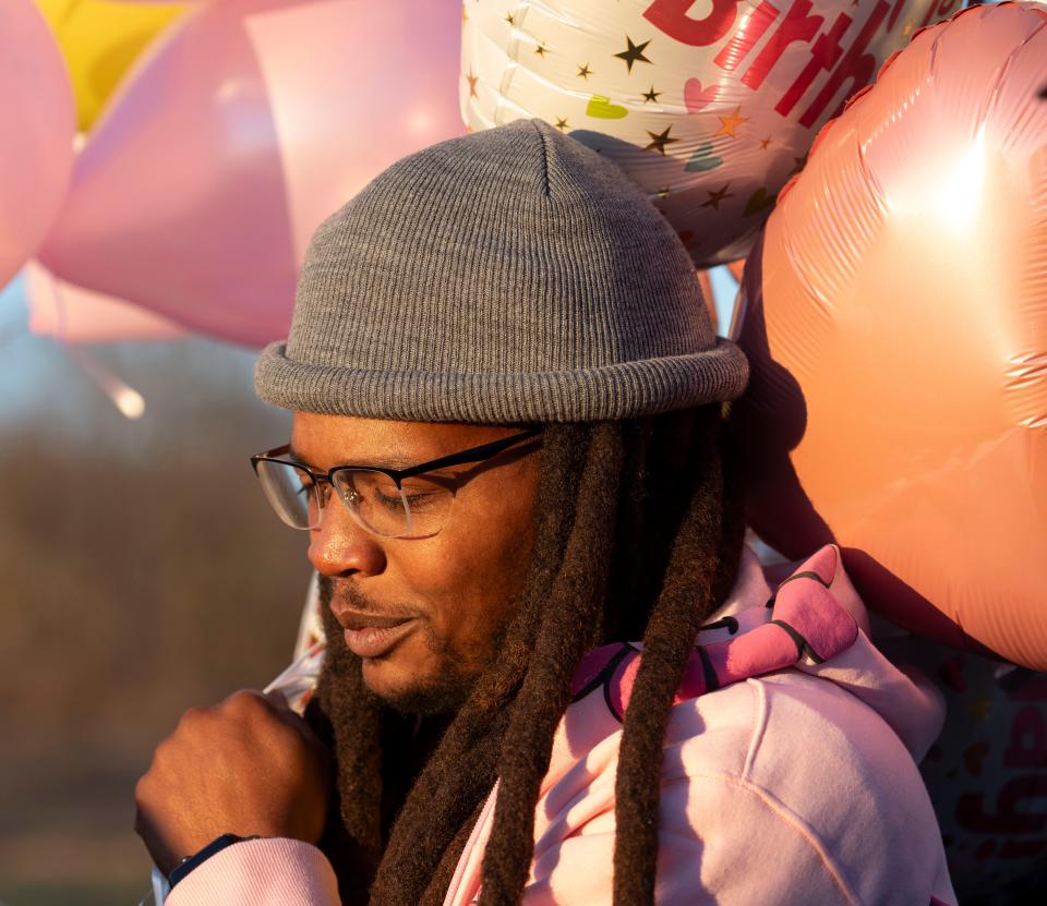 Quenton Boyd holds balloons as he gathers with friends and family to celebrate the life of his step-daughter, Serenity Wilson, on what should have been her seventeenth birthday Tuesday, Dec. 12, 2023, at her grave in Indianapolis.