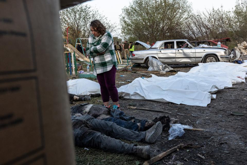 Family members look through the dead bodies at a destroyed village shop and café on October 5, 2023 in Hroza, Ukraine. A Russian missile strike killed at least 50 people in a village near the eastern Ukrainian city of Kupiansk, officials say one-fifth of the village died in the attack on civilians gathering at a wake in a cafe.