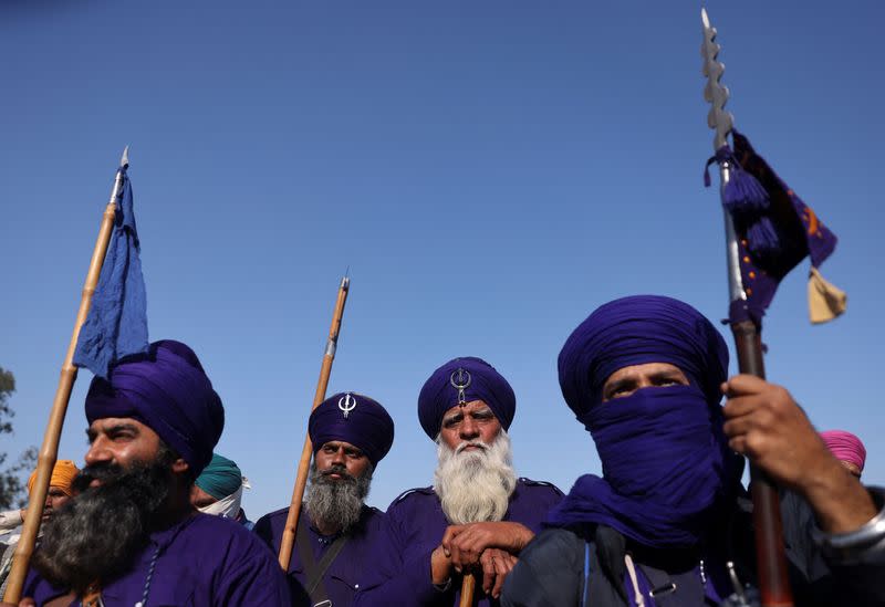 Nihangs or Sikh warriors listen to a speaker at a protest site where farmers are marching towards New Delhi to press for the better crop prices promised to them in 2021, at Shambhu Barrier