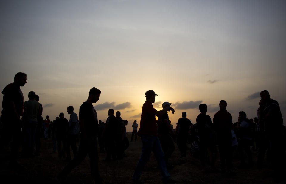 Palestinian protesters gather as they attend a protest at the Gaza Strip's border with Israel, Friday, Oct. 19, 2018. (AP Photo/Khalil Hamra)
