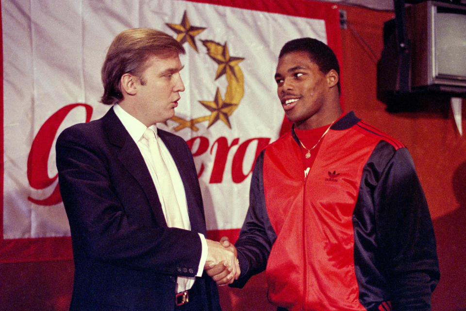 FILE - In this March 8, 1984, file photo, Donald Trump shakes hands with Herschel Walker in New York after agreement on a 4-year contract with the New Jersey Generals USFL football team. The original USFL was a league that made a whole lot of sense, only to be undone by the greed and hubris of owners such as former President Donald Trump, who saw the fledgling organization as a conduit to the NFL. (AP Photo/Dave Pickoff, File)