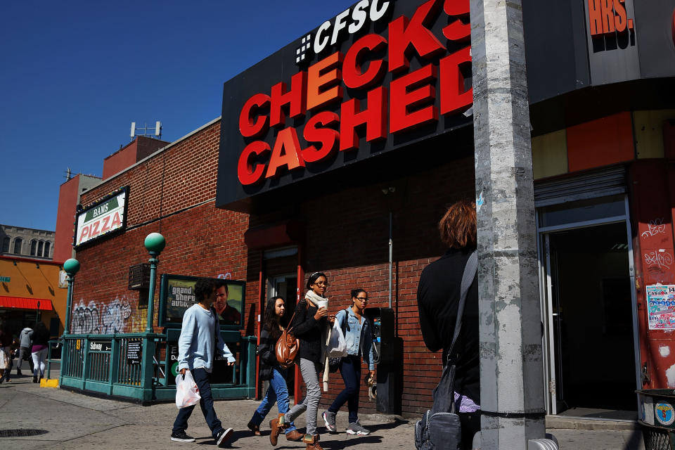 NEW YORK, NY - SEPTEMBER 19: People walk by a check cashing store in the South Bronx on September 19, 2013 in New York City.  According to the 2010 U.S. Census Bureau report, over a quarter-million people in the South Bronx are living in poverty, making the 16th Congressional District the poorest in the nation. New Census Bureau numbers for all of New York City show that the poverty rate has risen to 21.2 percent in 2012, from 20.9 percent the year before. As New Yorkers prepare to vote for their next mayor following Michael Bloomberg, the Democratic candidate Bill de Blasio has focused on the theme that New York has transformed into a "tale of two cities" under the Bloomberg administration.  (Photo by Spencer Platt/Getty Images)