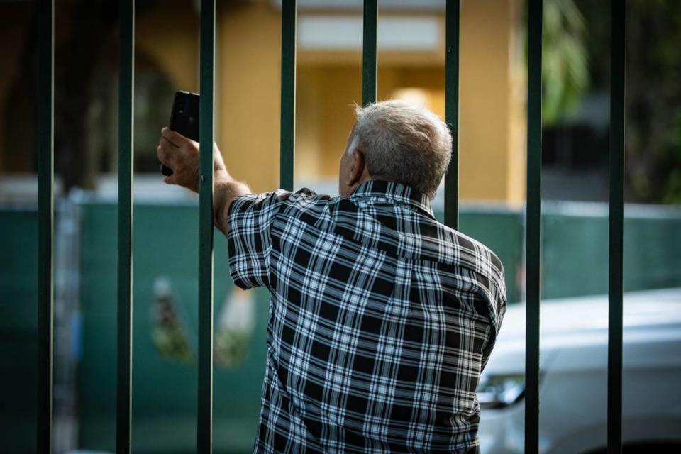 Former resident of Temple Court Apartments, Lazaro Lopez, 71, shows his partner Mercedes Gouthman the demolition of the building through a video call from Lummus Park on 404 NW Third St. on Tuesday, June 18, 2024 in Miami, Fla. They lived on the first floor and hoped to grab documents before the demolition. The city of Miami is demolishing the building because it says it’s unsafe after the fire and last week’s heavy rains.