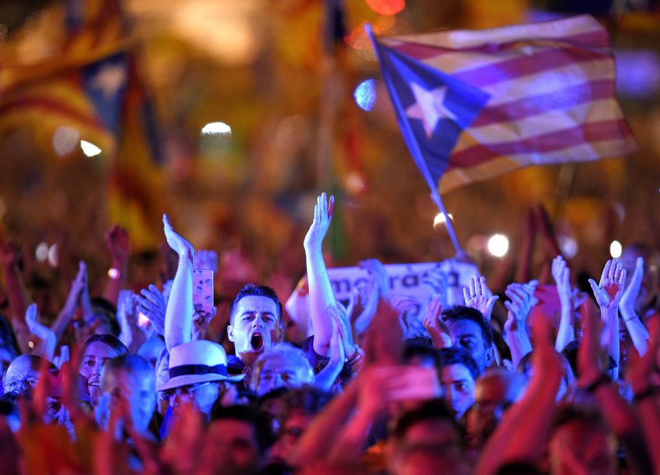 <p>People applaud during the closing meeting of the Catalan pro-independence groups and political parties that campaign for ‘Yes’ in the upcoming Oct. 1 referendum on self-determination in Catalonia, in Barcelona on Sept. 29, 2017. (Photo: Lluis Gene/AFP/Getty Images) </p>