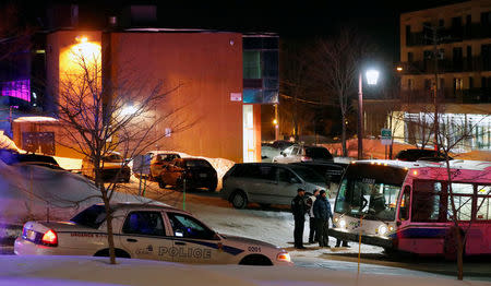 Police officers speak near a mosque after a shooting. REUTERS/Mathieu Belanger