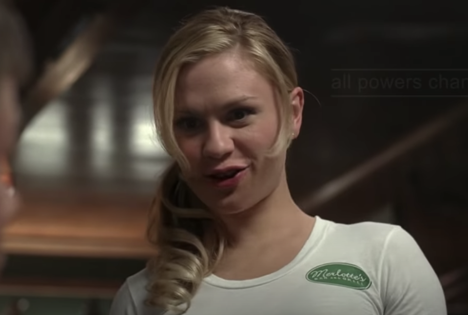 Sookie wearing a bar T-shirt with her blonde ponytail draped over her shoulder