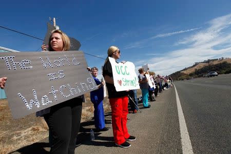 Supporters, including Cami Jones (L), of Roseburg, and Kaila Johnson (C), of Myrtle Creek, line the street outside the Church on the Rise as people arrive at the funeral service of Umpqua Community College student Jason Johnson in Roseburg, Oregon October 8, 2015. REUTERS/Amanda Loman