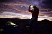 Maria Rivera, a 42-year-old seasonal worker, wears face mask to protect against coronavirus while collecting white asparagus from the field using lanterns in Uterga, around 15 km (9 miles) from Pamplona, northern Spain, Sunday, April 5, 2020. (AP Photo/Alvaro Barrientos)