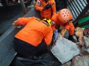 Members of a search and rescue agency team dig through rubble after an earthquake, in Mamuju