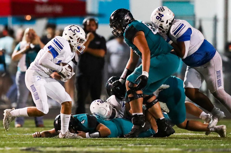 Barron Collier Cougars linebacker Dax Boogaard (12) catches a fumble from Gulf Coast Sharks quarterback Jace Seyler (4) with two minutes left in the fourth quarter of the Catfish Bowl at Gulf Coast High School in Naples on Friday, Nov. 3, 2023. The Cougars ran out the clock to win.