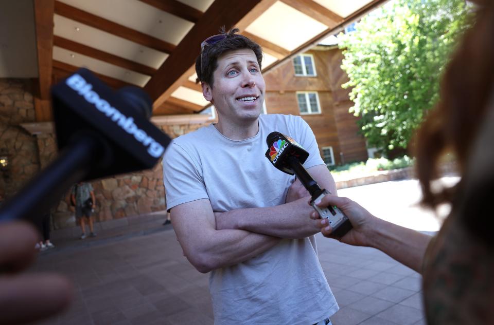 Sam Altman being interviewed by people with microphones.