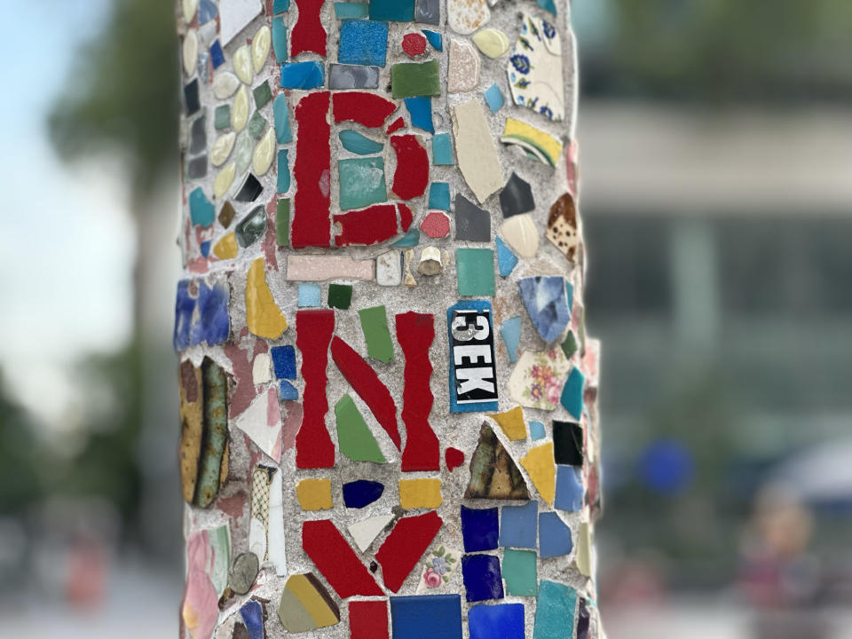 <p>A Portrait mode photo from the iPhone 14 Pro's main camera of colorful mosaic detail on a lamp post.</p>
