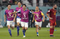 Spain's Dani Carvajal, right, reacts as Japan players celebrate after their win in the World Cup group E soccer match between Japan and Spain, at the Khalifa International Stadium in Doha, Qatar, Thursday, Dec. 1, 2022. (AP Photo/Aijaz Rahi)