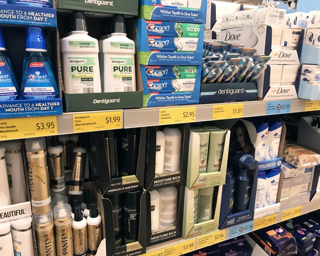 Closeup of 3 rows of toiletries in an Aldi store, hair care products, bath soaps, toothpastes, and more, organized in cardboard boxes