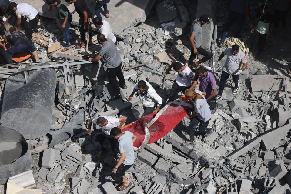 Evacuating a victim amid rubble following an Israeli airstrike on Rafah.