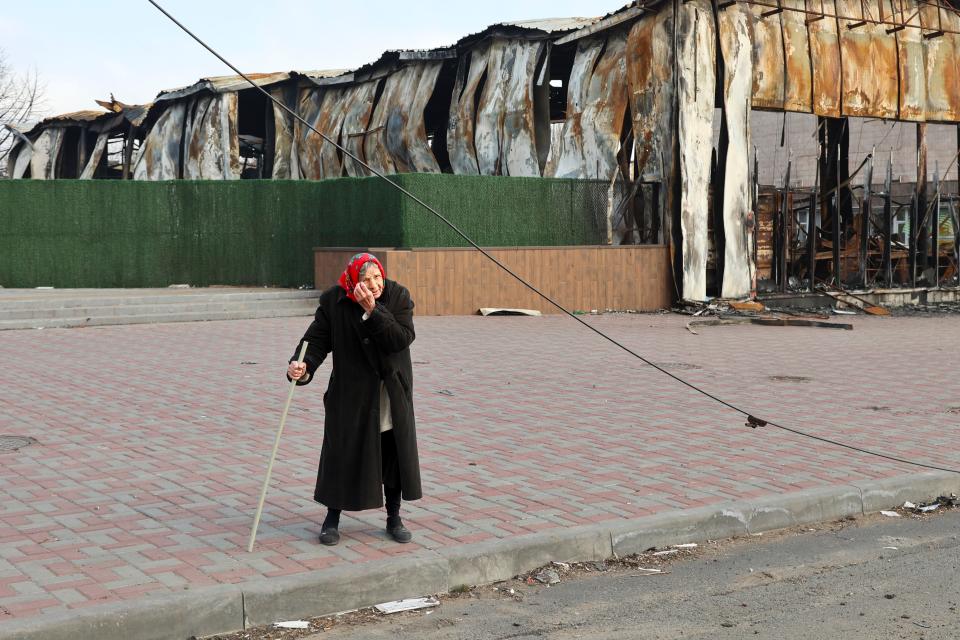 An elderly local resident stands behind a destroyed part of the Illich Iron & Steel Works Metallurgical Plant, the second largest metallurgical enterprise in Ukraine, in an area controlled by Russian-backed separatist forces in Mariupol, Ukraine, on April 16, 2022. Mariupol, a strategic port on the Sea of Azov, has been besieged by Russian troops and forces from self-proclaimed separatist areas in eastern Ukraine for more than six weeks.