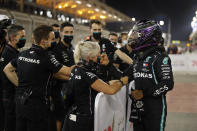 Mercedes driver Lewis Hamilton of Britain, right, celebrates with his teammates after winning the pole position after the qualifying session at the Formula One Bahrain International Circuit in Sakhir, Bahrain, Saturday, Nov. 28, 2020. (Hamad Mohammed, Pool via AP)
