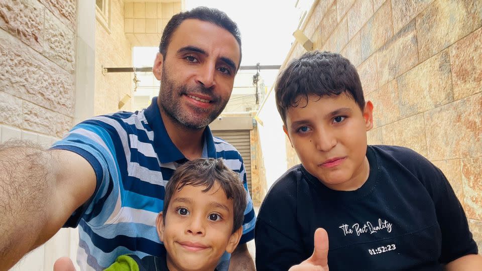 Al-Naizi stands with Hamza, age 3, and Muhammad, age 12, who has autism and is visually impaired in one eye, on November 9 at the new shelter. - Hazem Saeed Al-Naizi