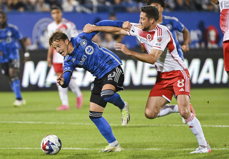 CF Montreal's Bryce Duke, left, is pressured by New England Revolution's Matthew Polster during the first half of an MLS soccer match Saturday, Aug. 26, 2023, in Montreal. (Graham Hughes/The Canadian Press via AP)