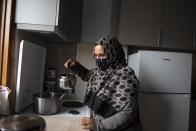 Kariman, 32, prepares tea at her family's apartment in the northern city of Thessaloniki, Greece, Saturday, May 1, 2021. Sundered in the deadly chaos of an air raid, a Syrian family of seven has been reunited, against the odds, three years later at a refugee shelter in Greece's second city of Thessaloniki. (AP Photo/Giannis Papanikos)