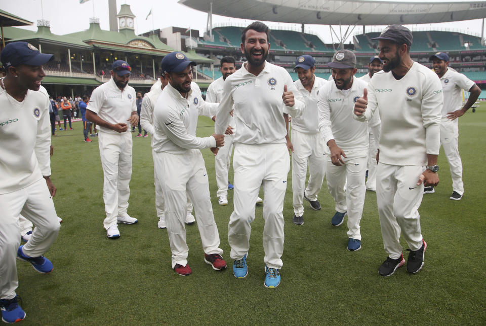 India's Virhat Kohli, right, encourages Cheteshwar Pujara, center, as the team dance as they celebrate their series win over Australia after play was called off on day 5 of their cricket test match in Sydney, Monday, Jan. 7, 2019. The match is a draw and India wins the series 2-1. (AP Photo/Rick Rycroft)