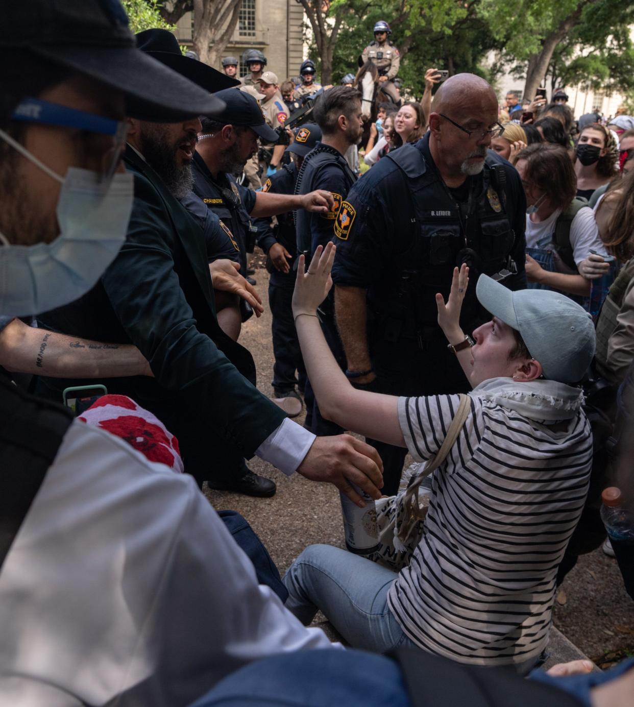 Police officers approach protesters to apprehend them during Wednesday's demonstration at the University of Texas.