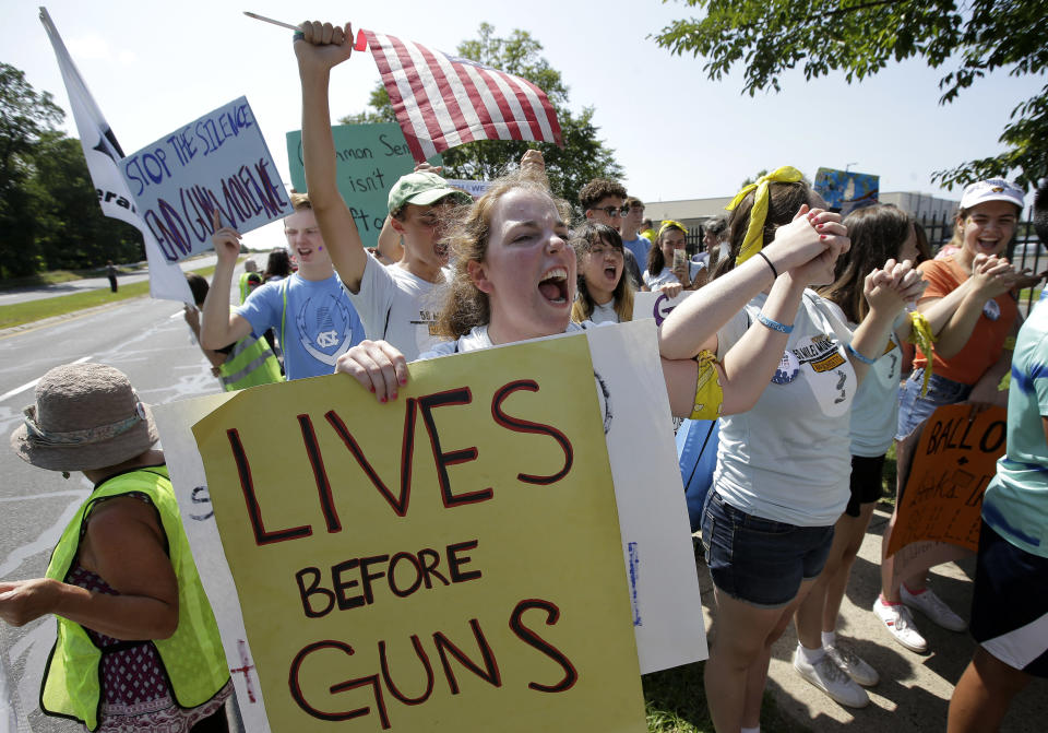 Chloe Carr, 18, of Natick, Mass., front, holds a placard and chants slogans during the final mile of a 50-mile march, Sunday, Aug. 26, 2018, in Springfield, Mass. The march, held to call for gun law reforms, began Thursday, Aug. 23, 2018, in Worcester, Mass., and ended Sunday, in Springfield, with a rally near the headquarters of gun manufacturer Smith & Wesson. (AP Photo/Steven Senne)