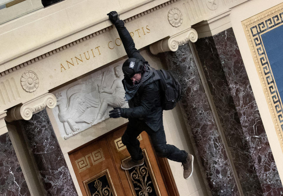 A protester supporting US President Donald Trump jumps from the public gallery to the floor of the Senate chamber at the US Capitol Building in Washington, DC. 