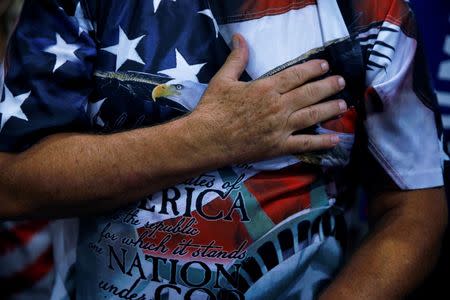 A supporter of Republican presidential nominee Donald Trump holds his hand over his heart as he recites the pledge of allegiance during a campaign rally in Phoenix, Arizona, U.S., August 31, 2016. REUTERS/Carlo Allegri