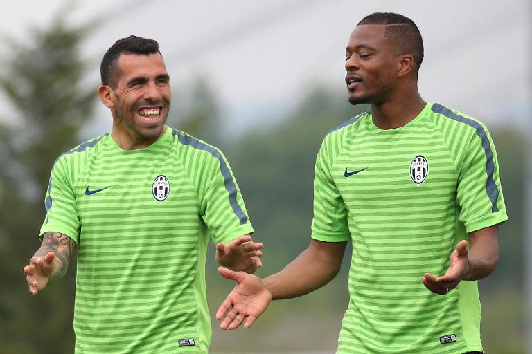 Juventus midfielder Patrice Evra (R) and forward Carlos Tevez take part in a training session on the eve of the UEFA Champions League semifinal football match Juventus vs Real Madrid on May 4, 2015