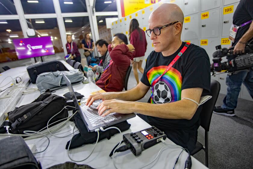 AL RAYYAN, QATAR - NOVEMBER 21: Journalist Grant Wahl (right) works in the FIFA Media Center.