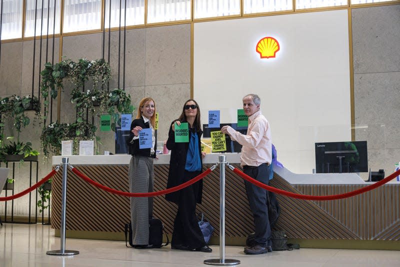 Extinction Rebellion activists are seen with their hands glued to the reception desk of the Shell Building on April 13, 2022 in London, England.