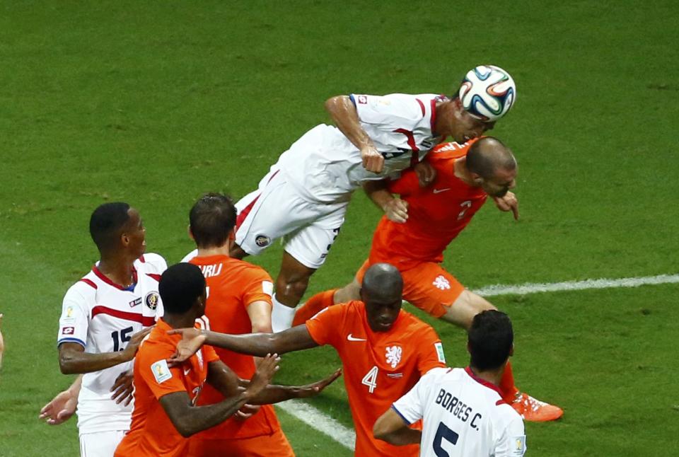 Costa Rica's Giancarlo Gonzalez jumps for the ball next to Ron Vlaar of the Netherlands during their 2014 World Cup quarter-finals at the Fonte Nova arena in Salvador July 5, 2014. REUTERS/Ruben Sprich