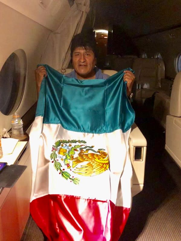 Former Bolivian President Evo Morales holds a Mexican flag onboard a Mexican government's aircraft