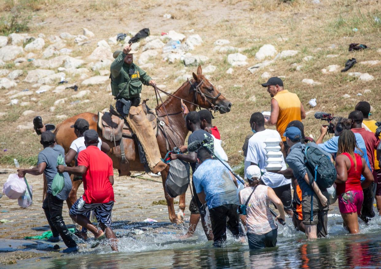 U.S. Border Patrol agents deter Haitians from returning to the U.S. on the bank of the Rio Grande after migrants crossed back to Mexico for food and water on Sept. 19, 2021.