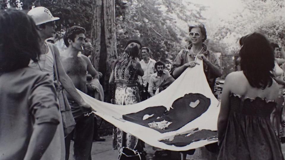 Armand Monroe, centre right, holds a flag at Montreal's first Pride march in 1979, alongside activist John Banks, left with hat. 