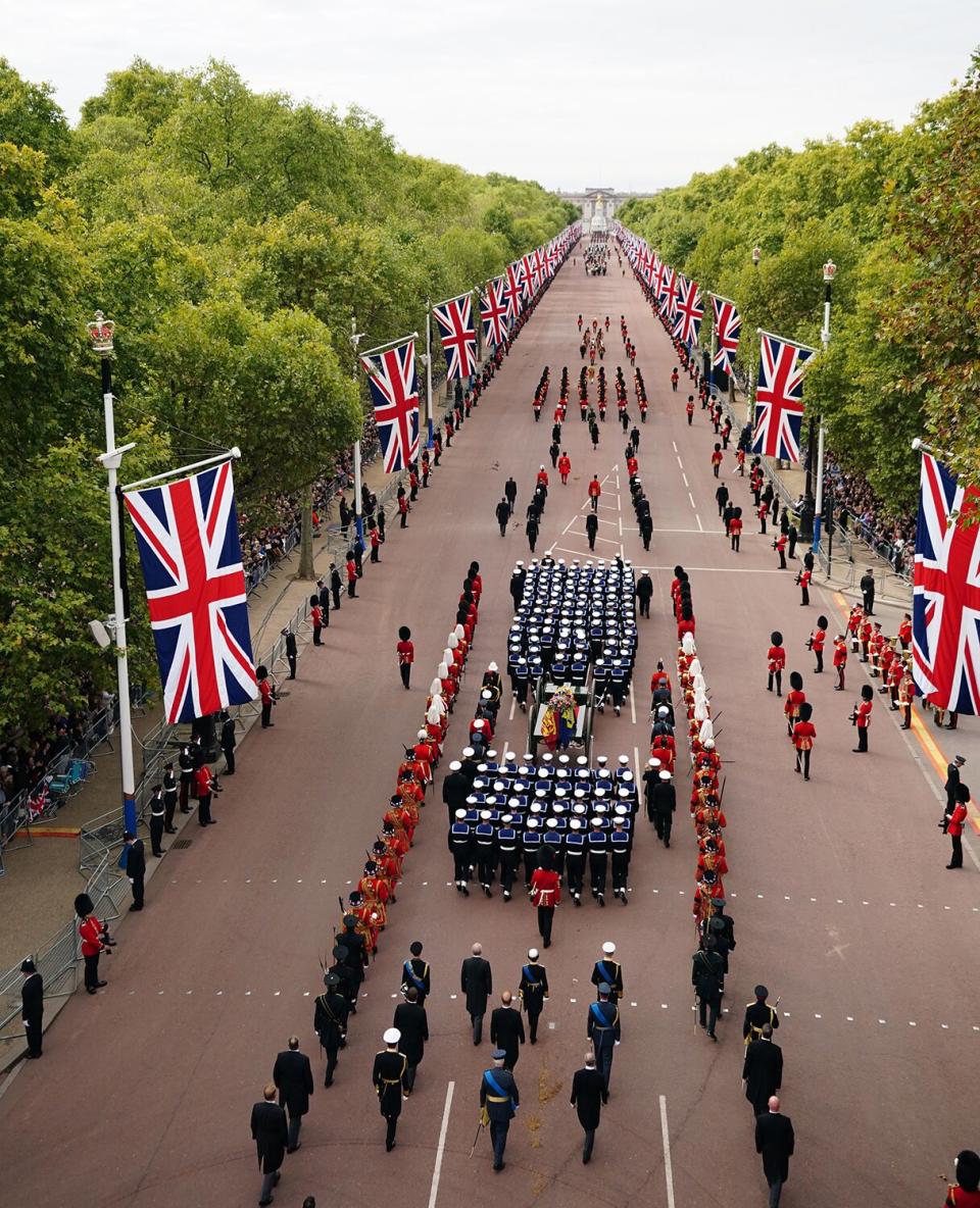 The State Gun Carriage carries the coffin of Queen Elizabeth II, draped in the Royal Standard with the Imperial State Crown and the Sovereign's orb and sceptre, in the Ceremonial Procession following her State Funeral at Westminster Abbey on September 19, 2022 in London, England.