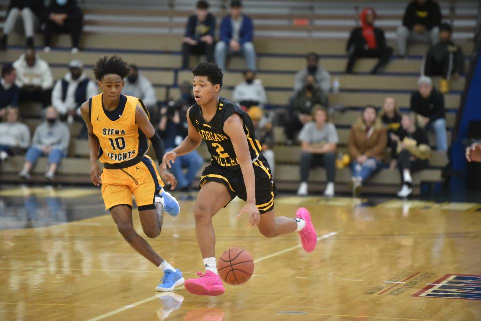 Adrian College's De'Ovion Price (2) brings the ball up court in the first half of Tuesday's Battle of the Milk Jug rivalry game against Siena Heights University at the SHU Fieldhouse in Adrian.