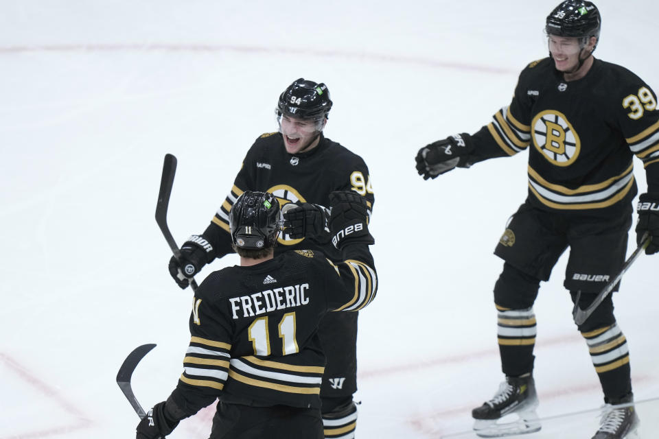 Boston Bruins center Jakub Lauko (94) celebrates with fellow centers Trent Frederic (11) and Morgan Geekie (39) after scoring in the first period of an NHL hockey game against the Colorado Avalanche, Thursday, Jan. 18, 2024, in Boston. (AP Photo/Steven Senne)